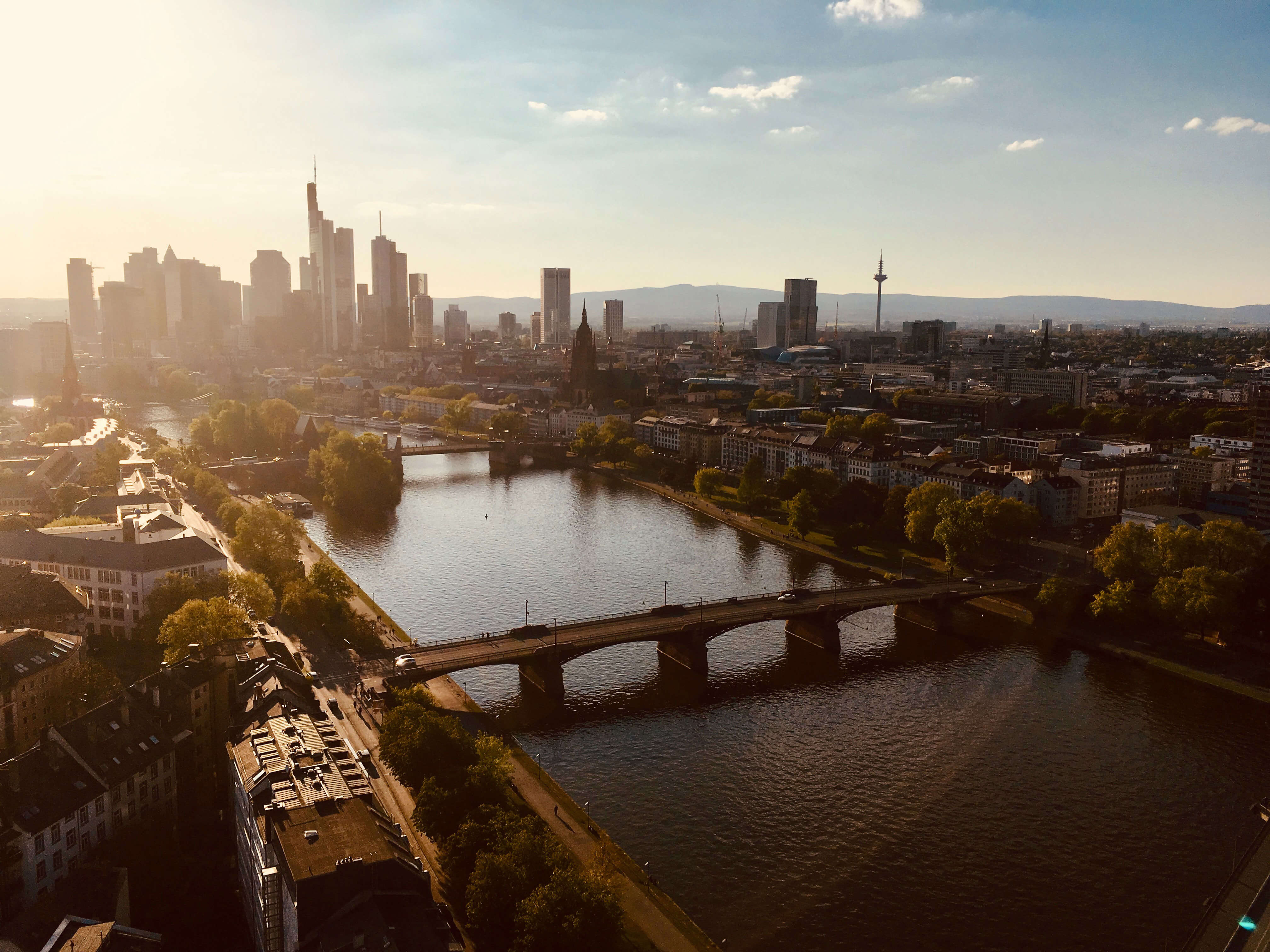 Aerial view capturing the evening mood of a big city skyline with skyscrapers and traditional houses and a river