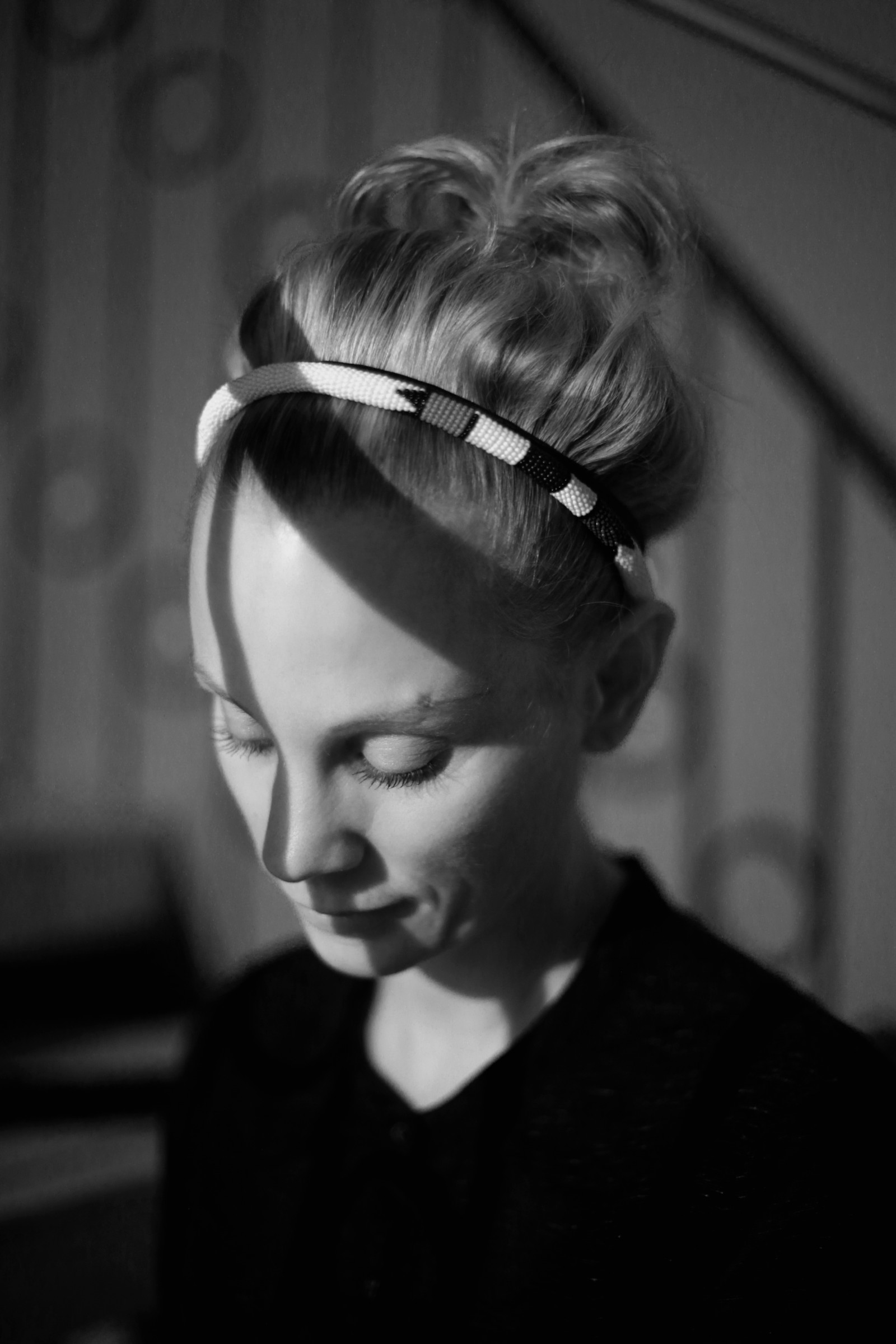 Sandra, eine lächelnde, junge Frau, die auf den Boden blickt