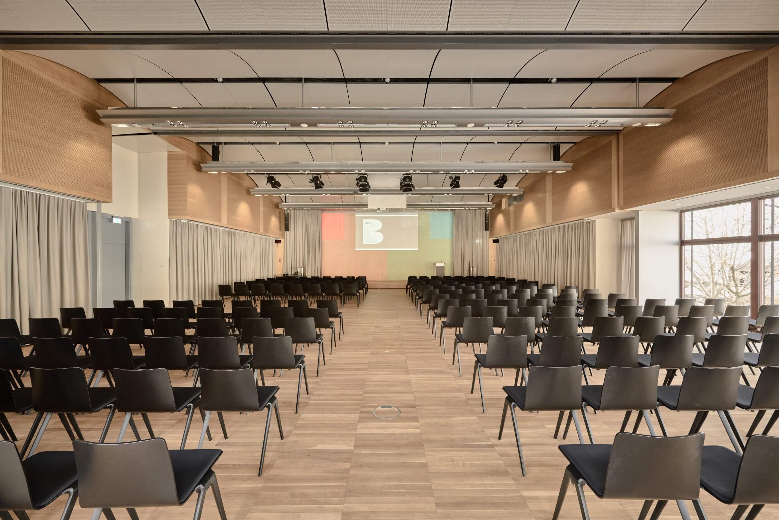 Eine Totale von The Hall im Bold Campus mit Blick auf die Bühne. Auf der Wand ist an der Bühne ist das Bold Logo zu sehen. 