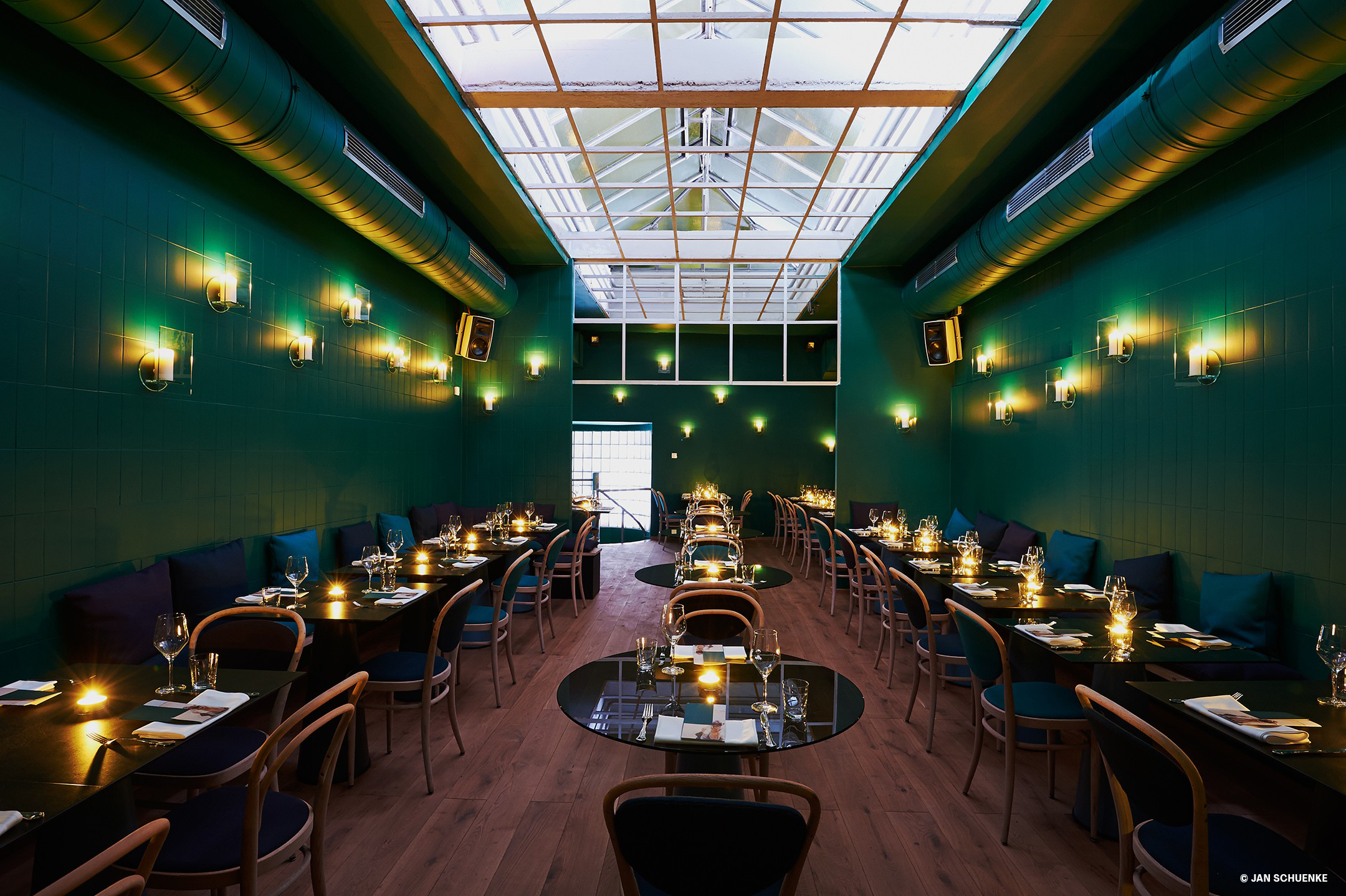 Set dark tables and wooden chairs in a noble-looking restaurant decorated in inky colours