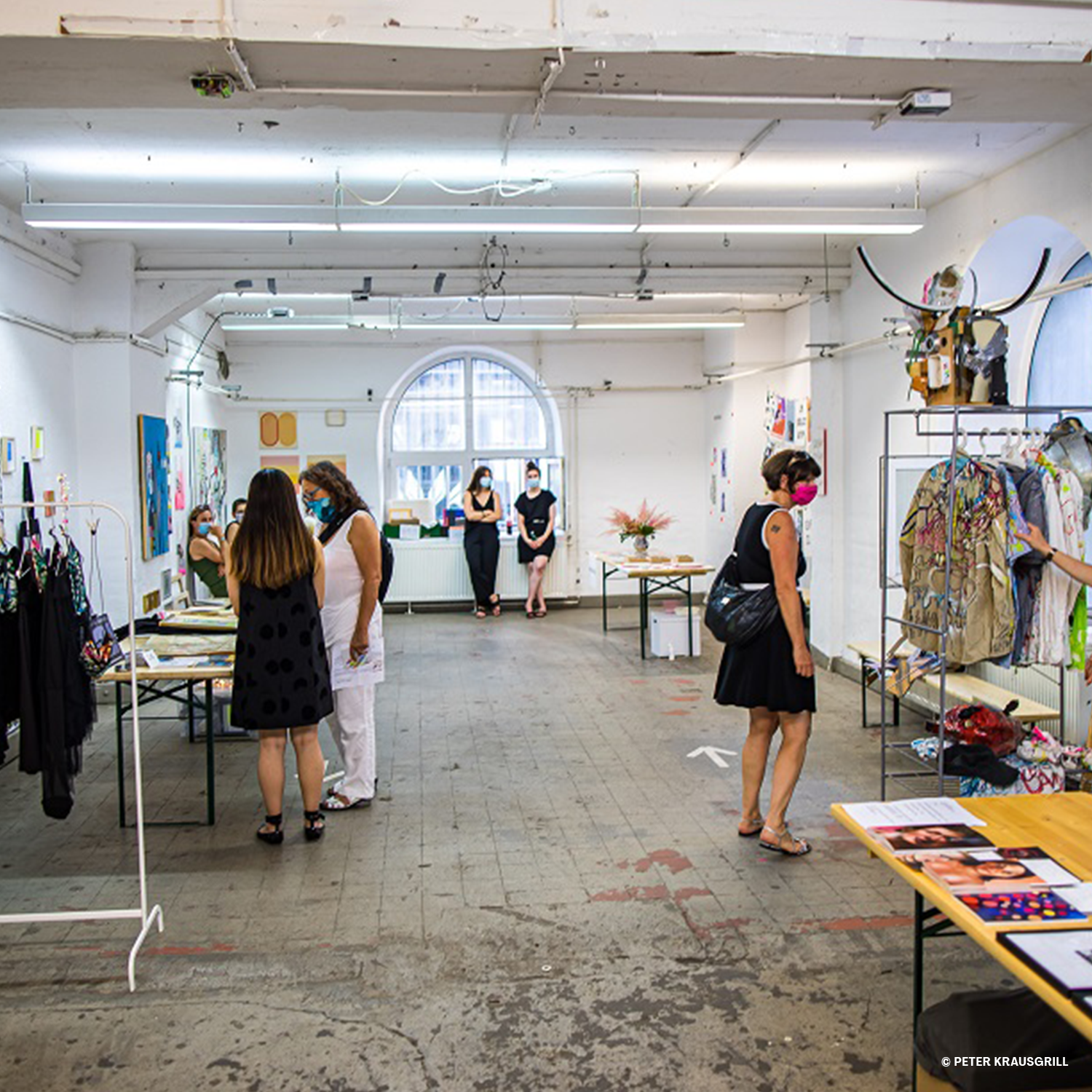 Ein industrieller Raum mit verschiedenen Kustwerken, Mode und verschiedenen, weiteren Ausstellungsstücken.