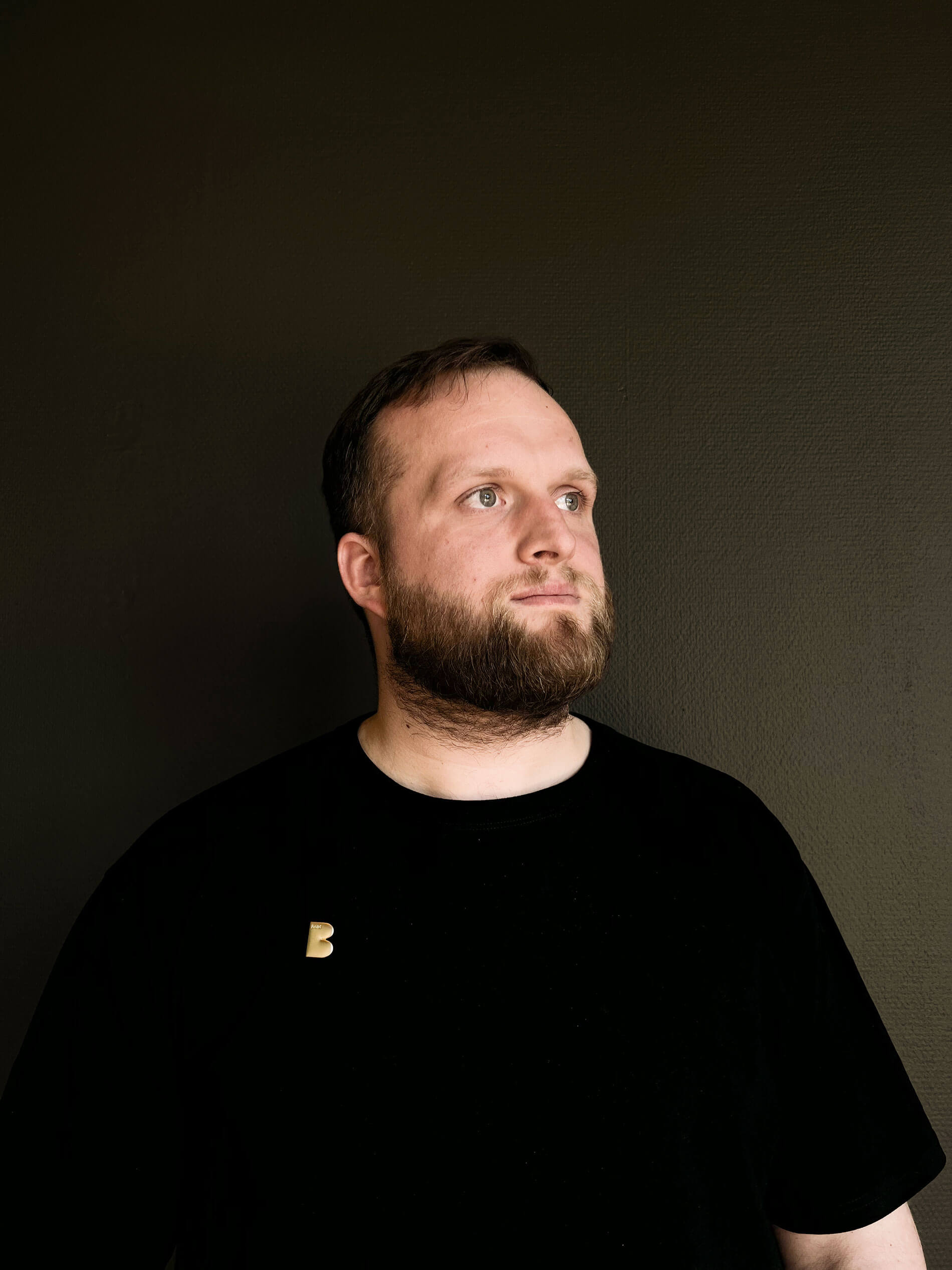 Adrian, bodenständig und Bold mit kurzen, dunklen Haaren