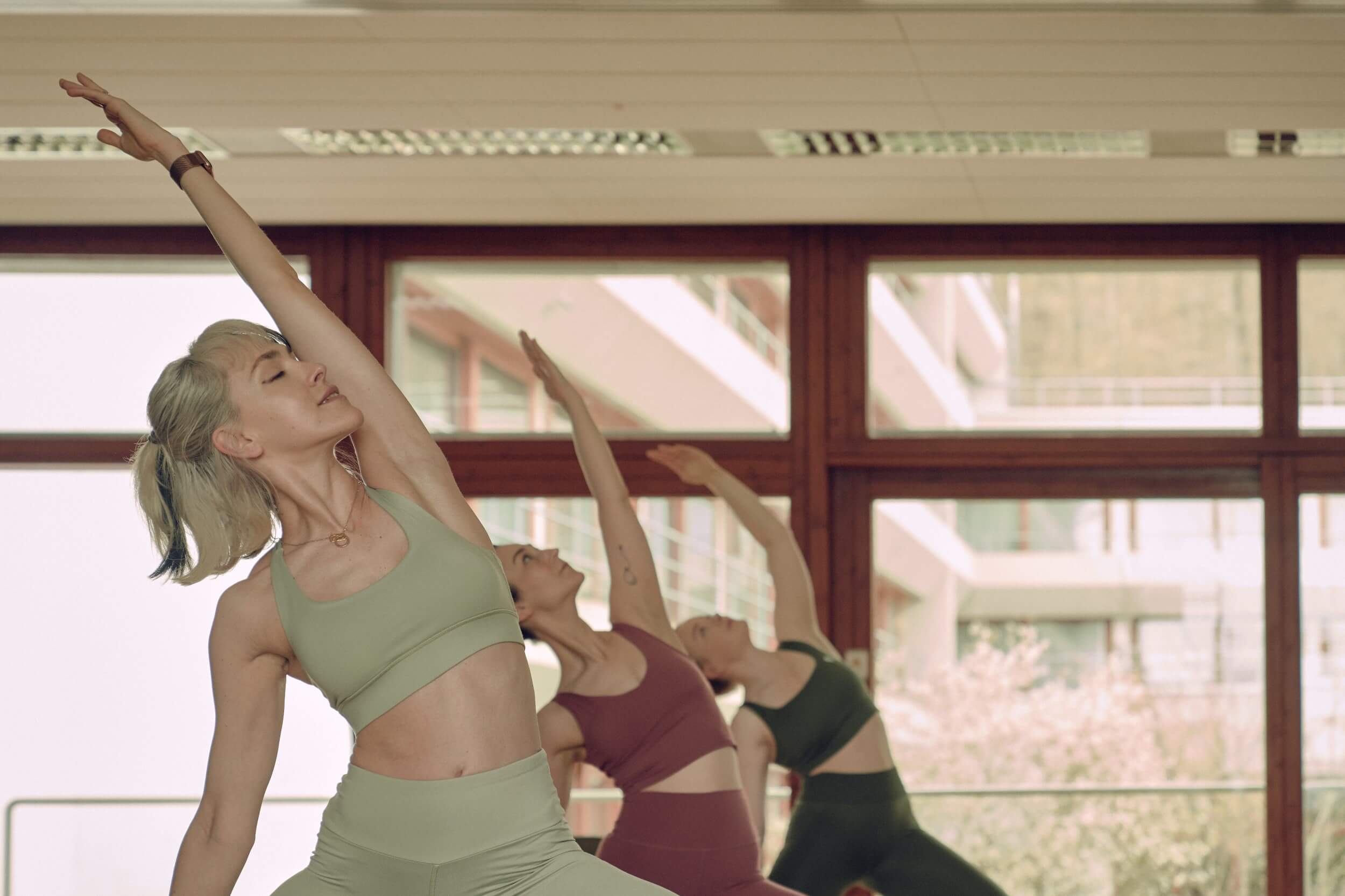 Three women doing the peaceful warrior yoga pose