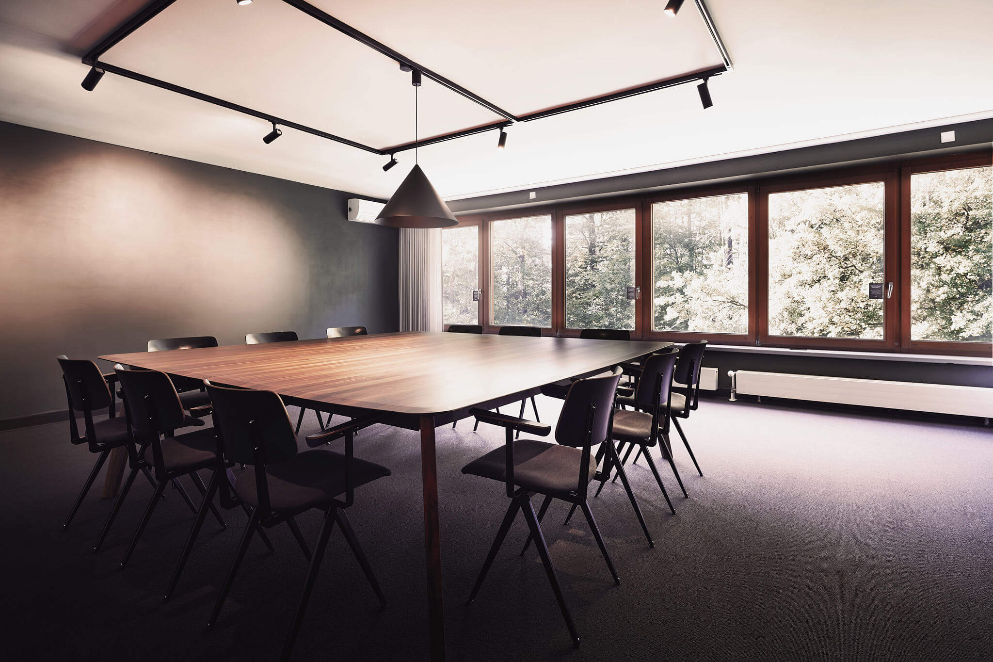 Ein Tagungsraum mit großen Fenstern mit Blick direkt ins Grüne.