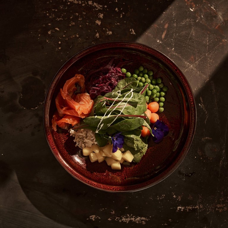 Eine lecker aussehende Bowl mit frischem Spinat, Lachs und mehr