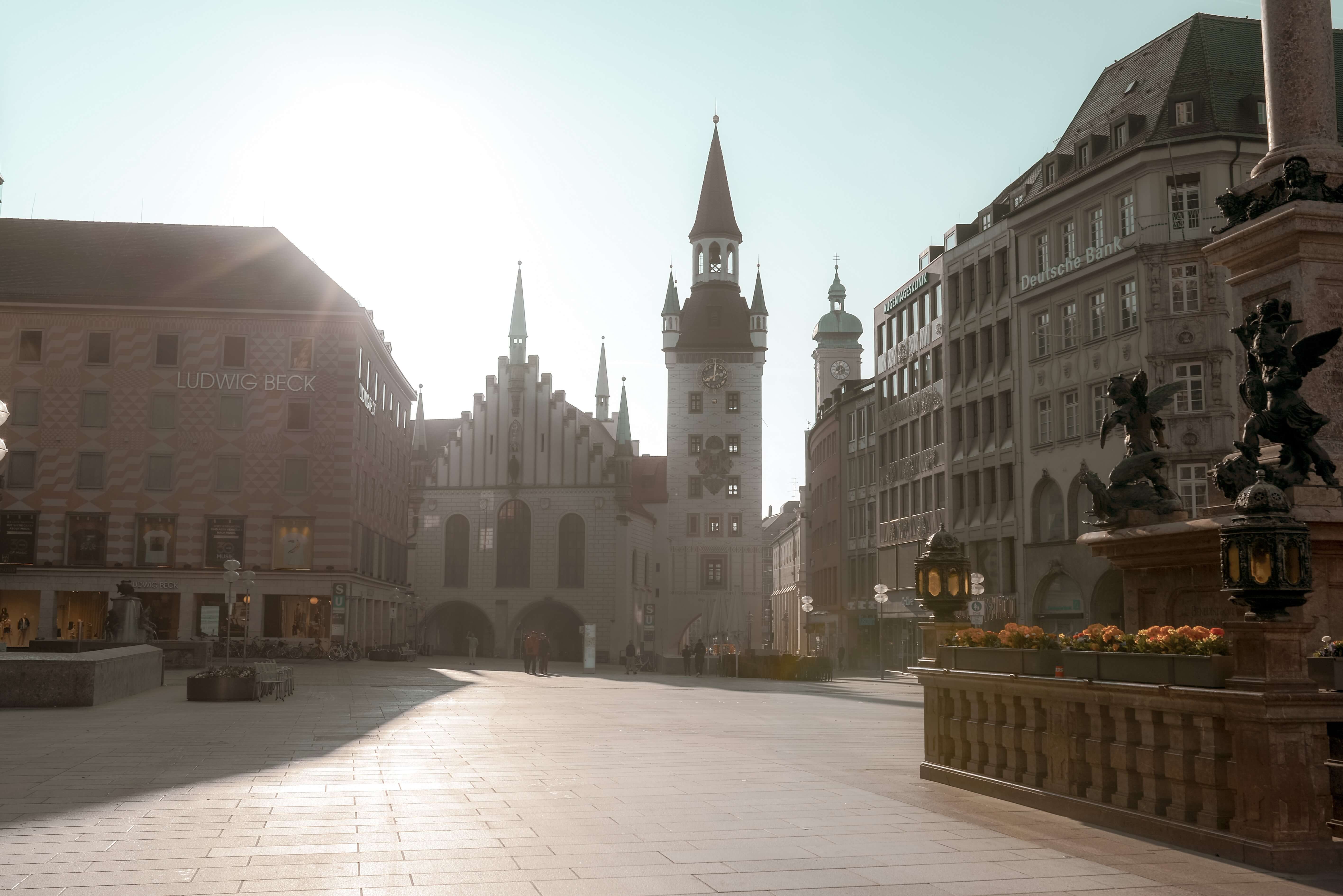 Ein Platz in sanftem Morgenlicht, rund herum sind historische Gebäude und Kaufhäuser
