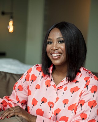Portrait of a smiling Motsi Mabuse in an eye-catching blouse