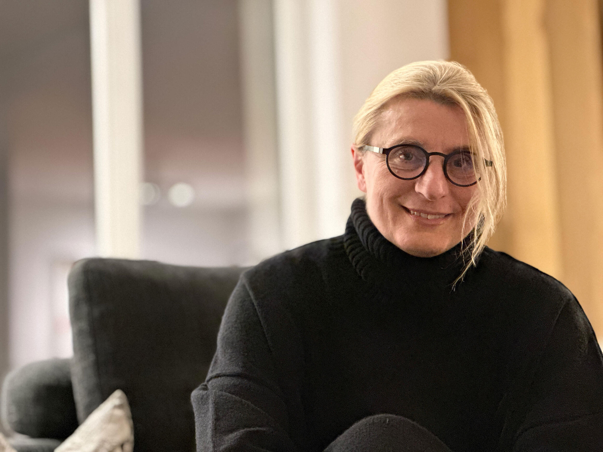 Wilma Mankel, a smiling woman with long blonde hair and glasses